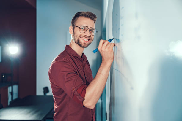 istock Happy young man is looking at camera in office 1190602174