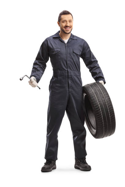 istock Auto mechanic holding a wrench and a tire 1190602436
