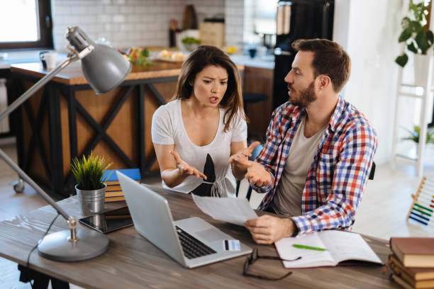 istock Frustrated couple checking bills at home using laptop 1190602680