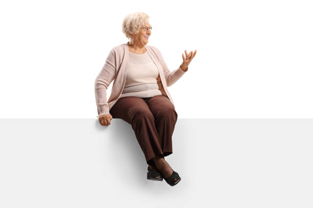 istock Elderly woman sitting on a panel looking to the side and gesturing with hand 1190603338
