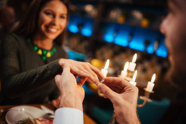 istock Man putting ring on his girlfriend's finger 1190604114