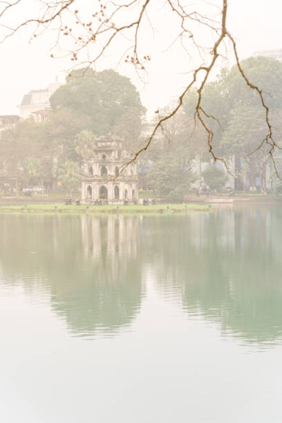 istock Bare terminalia catappa (Cay Bang) branches with Tortoise Tower in background, Hoan Kiem Lake 1190604899