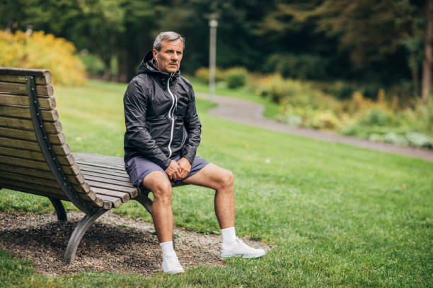 istock Fit senior man sitting on bench after jogging in park 1190616436
