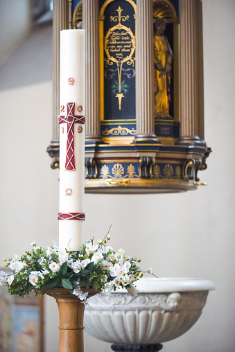 Large candle in church interior to celebrate christmas and new year with religious symbol