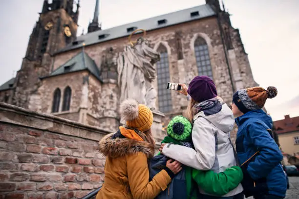 Mother with three kids sightseeing city of Brno. Family is photographing the Cathedral of St. Peter and Paul in the old town of Brno.
Nikon D850