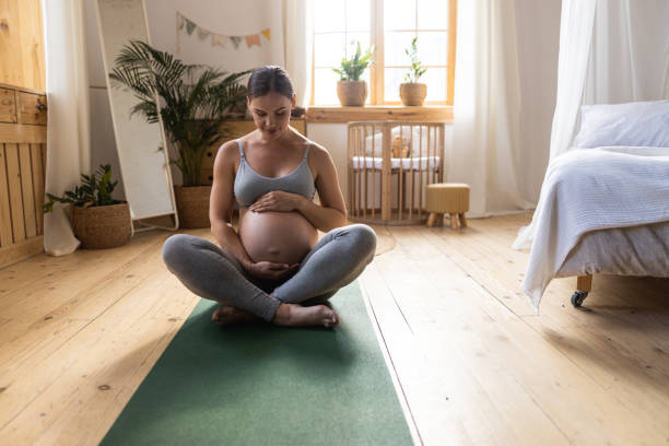 istock Pretty expectant mother looking at her belly 1190626298