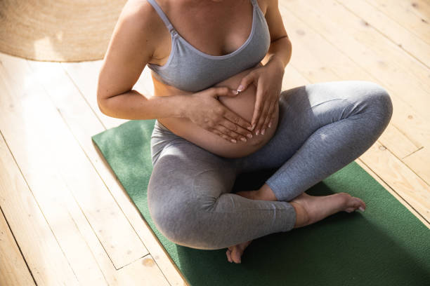 istock Young expectant mother sitting on exercise mat 1190626325