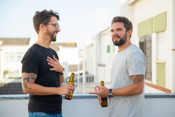 istock Positive male friends chatting and drinking beer 1190626714