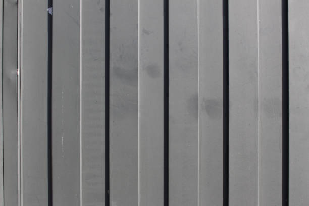 Closeup of gray metal gate with elements that draw vertical lines