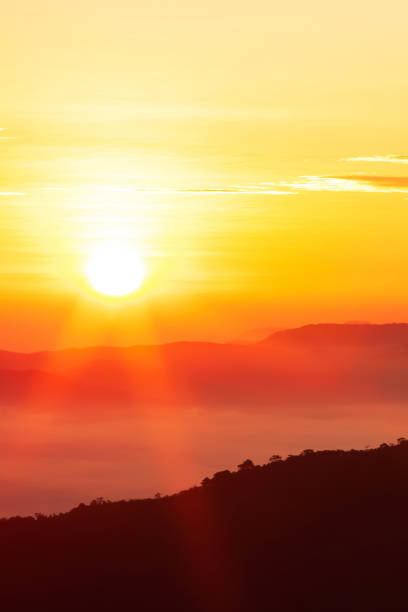 Glowing sunrise shines over mountain range, magical star shape ray from the sun with lens flare. Exploration, inspiration concept.