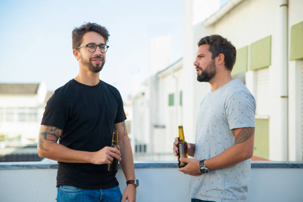 istock Two male friends drinking beer and talking 1190630896