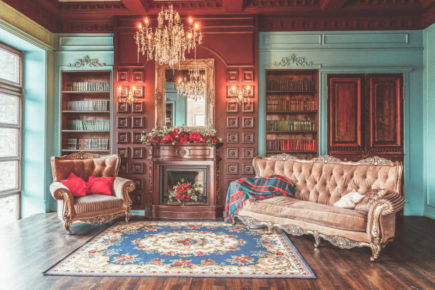 Luxury classic interior of home library. Sitting room with bookshelf, books, arm chair, sofa and fireplace Luxury classic interior of home library. Sitting room with bookshelf, books, arm chair, sofa and fireplace. Clean and modern decoration with elegant furniture. Education read study wisdom concept victorian style stock pictures, royalty-free photos & images