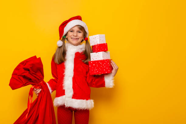 istock Child dressed as Santa carrying Christmas presents 1190633367