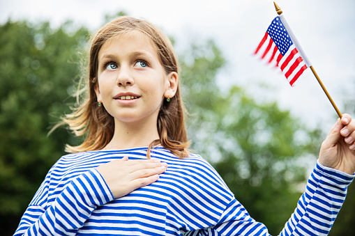 young patriot girl, holding an American flag