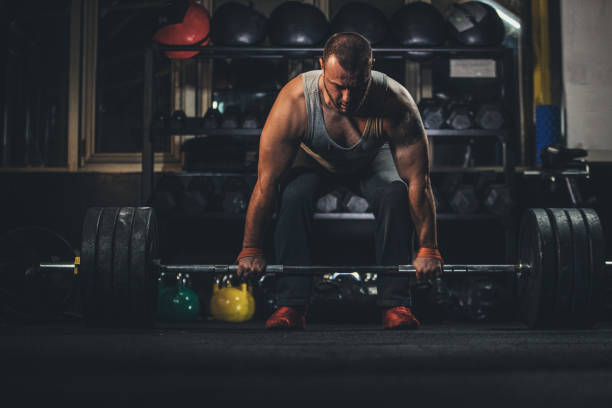 istock Body builder weightlifting in gym alone 1190635519