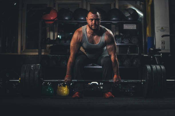 istock Man weightlifting in dark gym 1190635657