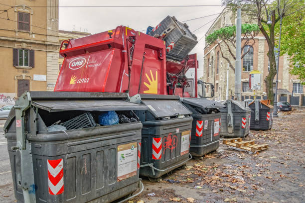 Municipal AMA trash vehicle on the streets of the Roman capital, loading full dumpsters. stock photo