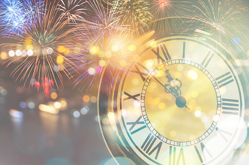 Vintage clock at midnight and colorful firework on bokeh lights background for New Year celebration concept