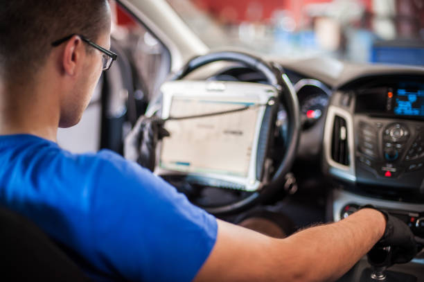 istock Automobile computer diagnosis. Car mechanic repairer looks for engine failure 1190638689