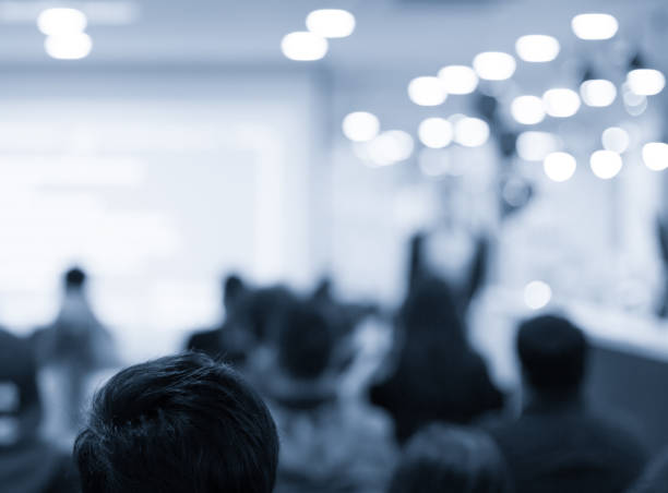 istock Conference photo audience and speaker giving speech. Seminar presenter on a panel during forum. Corporate manager in sales executive training discussion on stage. Investor pitch presentation. 1190638788