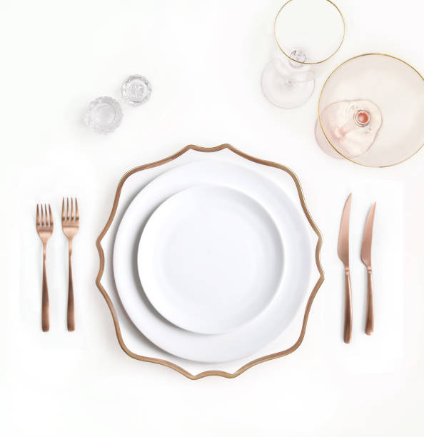 istock New luxury white ceramic plate, copper cutlery view from above on a isolated background. Top view. Knife and fork for a festive table for a wedding, birthday or party. 1190640296