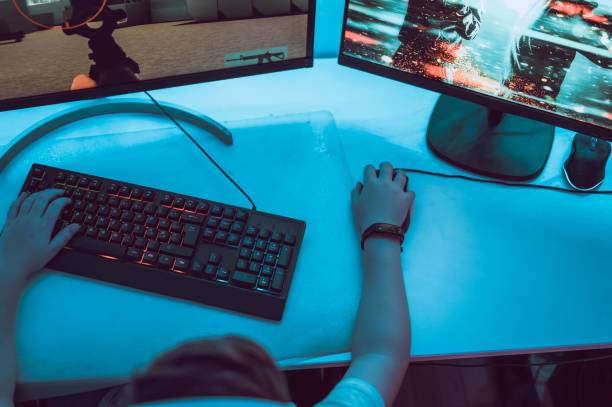 istock Using computer mouse to play online video game on pc at home 1190641568