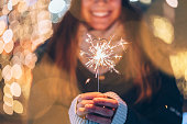Girl holding burning sparkler during Christmas