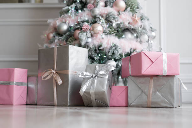 istock Wrapped gift boxes under the Christmas tree. Christmas tree decorated with festive decor of luminous garlands, Assorted Baubles and decorative snow. 1190641886