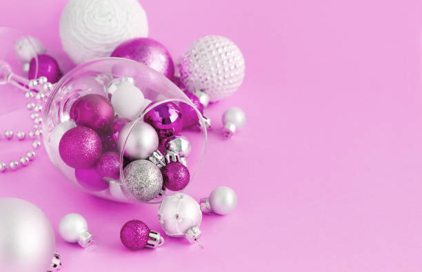 istock Christmas baubles in a wine glass on a light pink background 1190643532