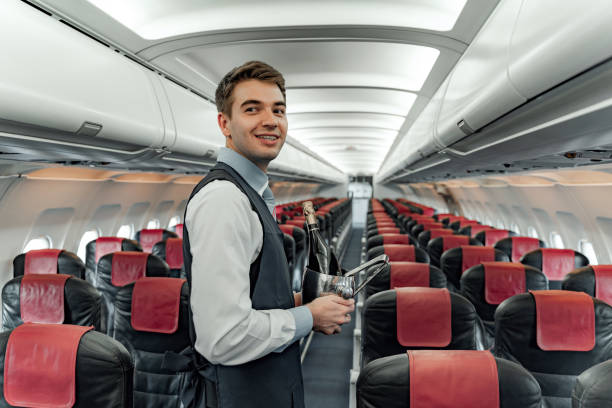 istock Smiling air steward is posing on camera in cabin 1190645083