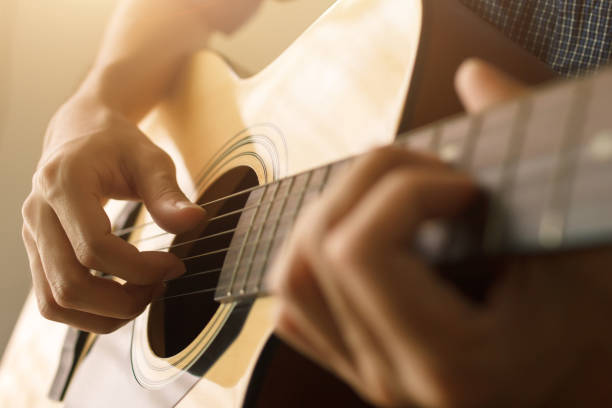 die hand des mannes spielt akustische gitarre - gitarre stock-fotos und bilder