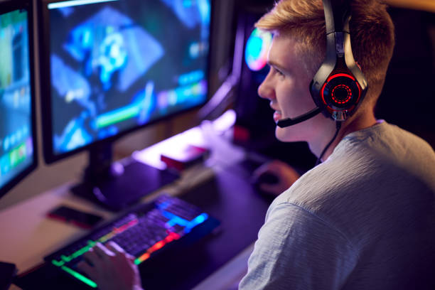 istock Teenage Boy Wearing Headset Gaming At Home Using Dual Computer Screens 1190646182
