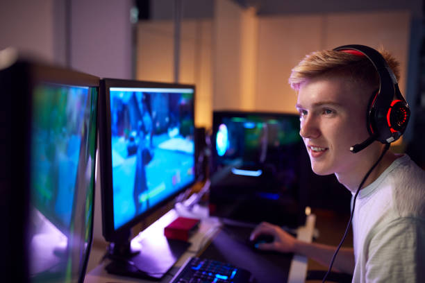istock Teenage Boy Wearing Headset Gaming At Home Using Dual Computer Screens 1190646246