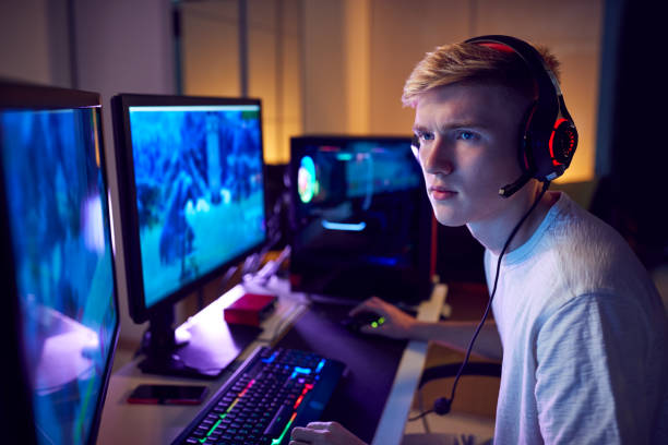 istock Teenage Boy Wearing Headset Gaming At Home Using Dual Computer Screens 1190646650