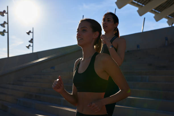 istock Two young woman jogging in the sunlight 1190647711