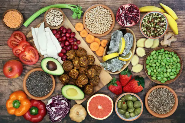 Super food for a healthy eating concept with health foods high in antioxidants, anthocyanins, vitamins, minerals, protein, smart carbs, omega 3 and fibre. Flat lay on rustic wood background.