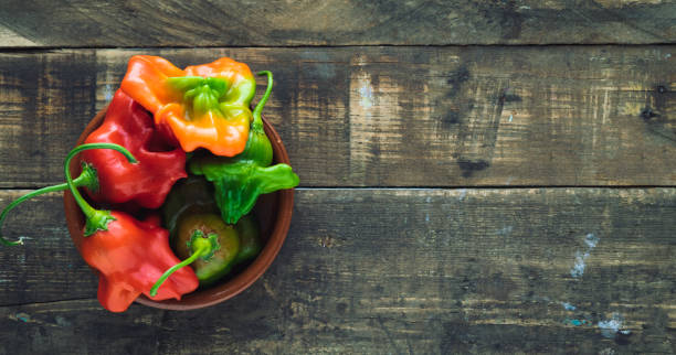 istock Peppers in bowl on rustic wooden background. Copy space. 1190649824