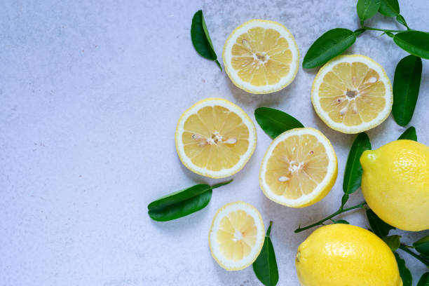 citron frais tranché avec des feuilles - lemon textured peel portion photos et images de collection