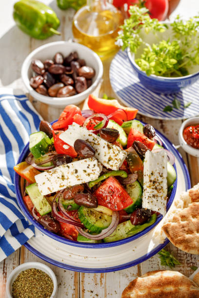 salade grecque. salade grecque traditionnelle composée de légumes frais comme les tomates, concombres, poivrons, oignons, origan et huile d'olive - greek culture salad olive feta cheese photos et images de collection