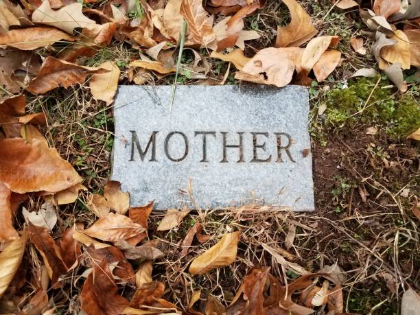 mother on granite or marble grave stone in cemetery with leaves