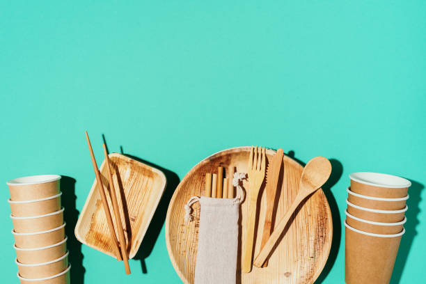 istock Bamboo plates, wooden spoon, fork, knife, craft paper cups on blue background. Disposable tableware from natural materials. Sustainable lifestyle concept. Eco-friendly disposable utensils 1190660270