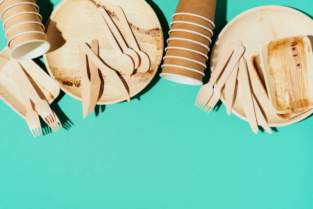 istock Disposable tableware from natural materials. Bamboo plates, wooden spoon, fork, knife, craft paper cups on blue background. Eco-friendly sustainable lifestyle. Eco-friendly disposable utensils 1190660321