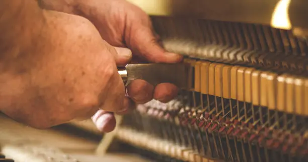 Instrument technician repairing a piano