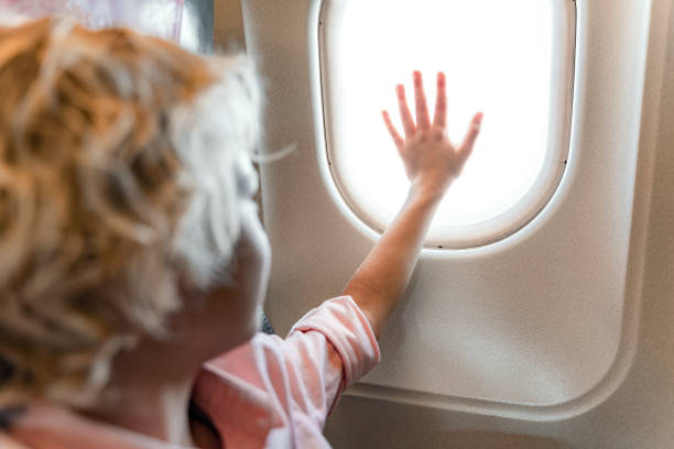 istock Smiling little boy looking at window in airplane 1190663498