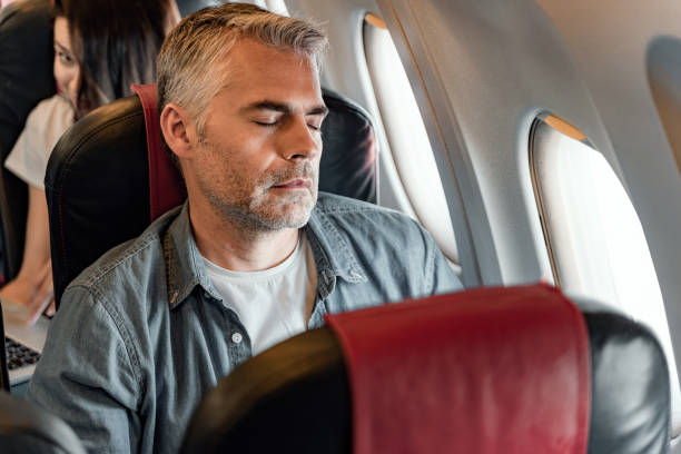 istock Adult man is sleeping near window in plane 1190663562