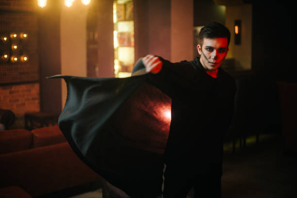 istock Young man in a Halloween costume is developing his cloak. 1190664269
