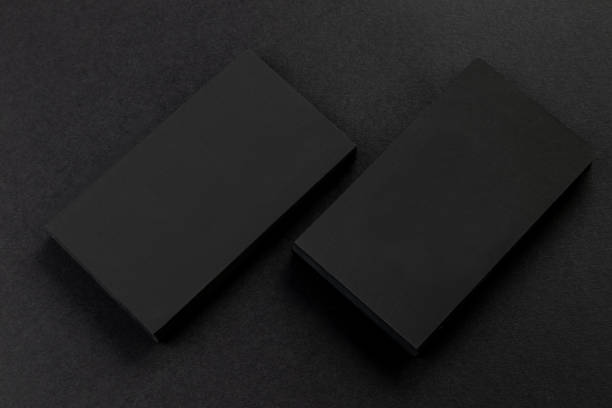istock Two vertical business cards stacks at black textured paper background for mockup. 1190664340