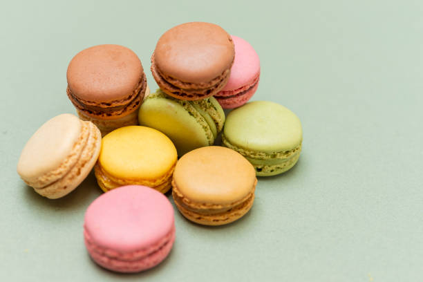 istock Colored tasty  macaroons over a green background 1190664682