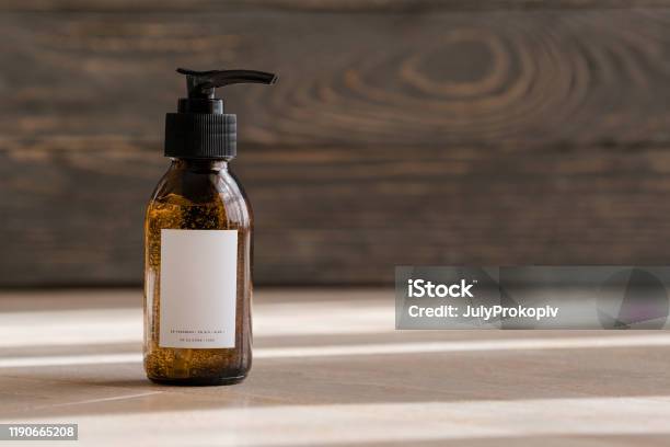 Cosmetic Dark Amber Bottles On Wooden Table Stock Photo - Download Image Now - Merchandise, Bottle, Shampoo