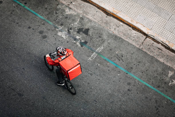 consegnare cibo in bicicletta in città - corriere foto e immagini stock